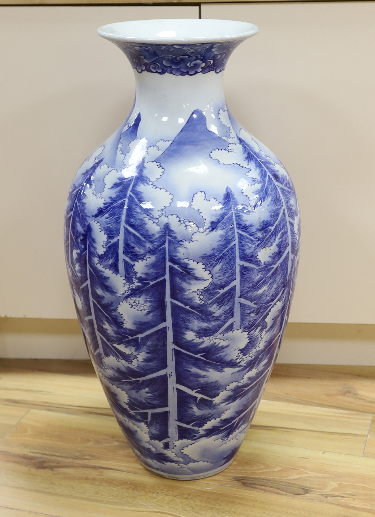 A large Japanese Arita blue and white vase, late 19th century, decorated with pine trees and mountains, 79cm high